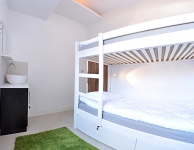 El dormitorio mixto de 4 personas con un lavabo y unos armarios cerrados para llave para cada cama. Tamaño de la habitación - 10 m2. Cuarto de baño compartido